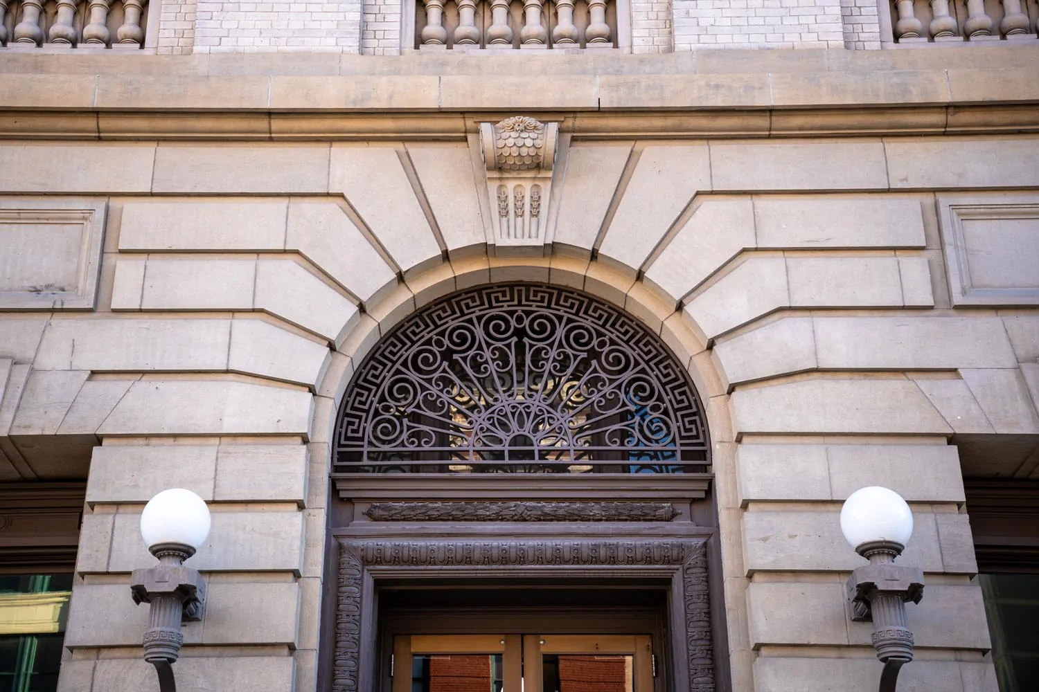 Historic stone archway with detailed ironwork above a doorway in downtown Boise, reflecting craftsmanship and civic dignity.