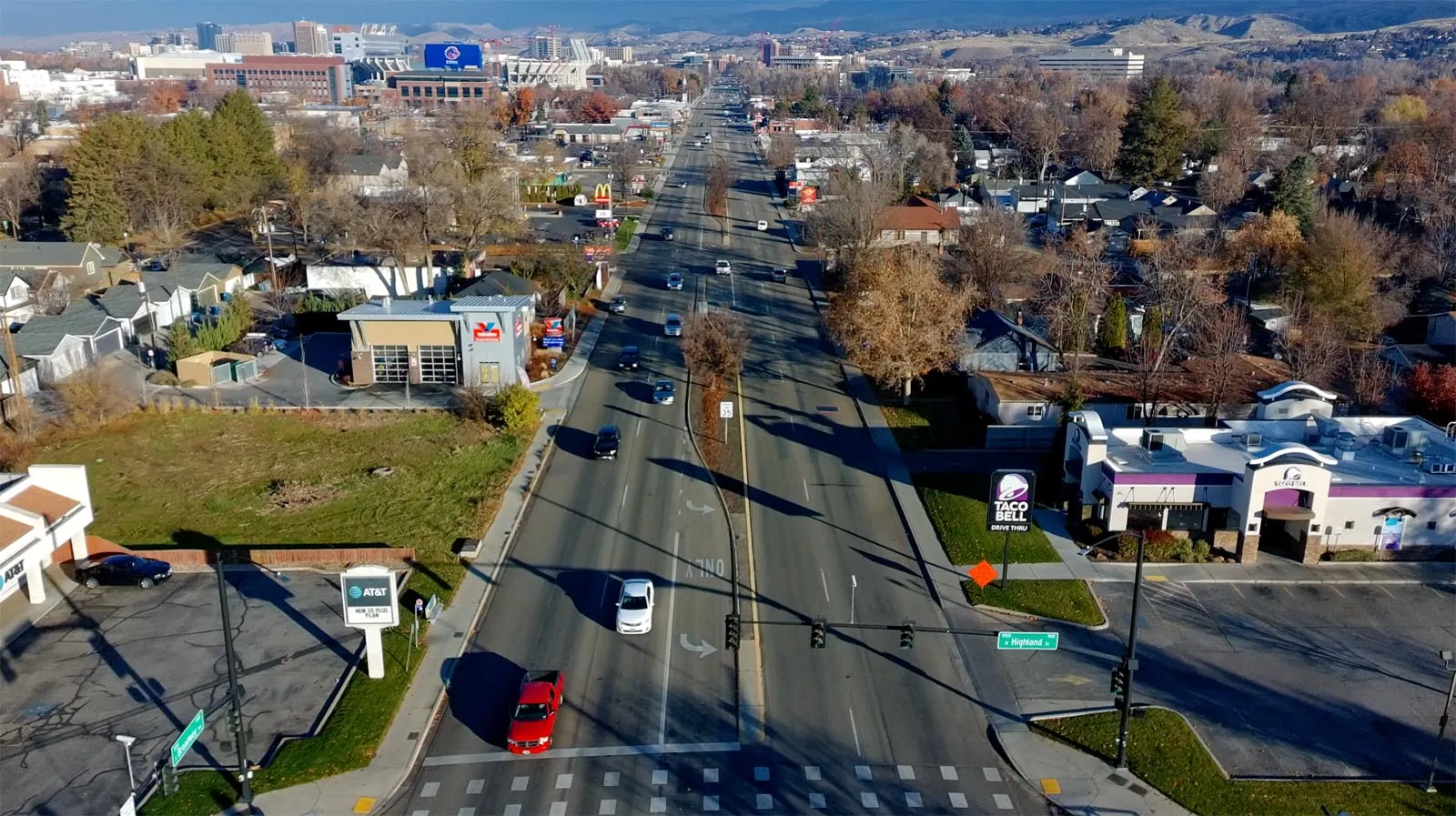 Sunken Broadway Before Existing Broadway Avenue at Highland Street with wide travel lanes, commercial frontage, and minimal pedestrian space.