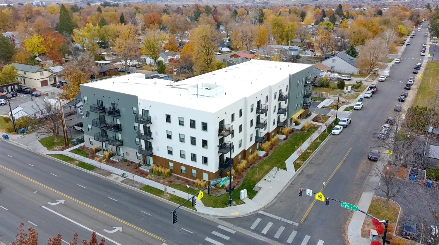 The Betty Before A recently built apartment building along Vista Avenue in Boise, showing a multi-story block design with units stacked above and beside one another, set close to a busy arterial road.