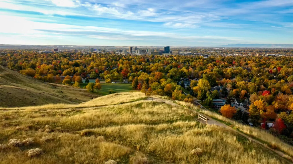 View from the Boise foothills showing a dirt trail in the foreground and the city below in autumn