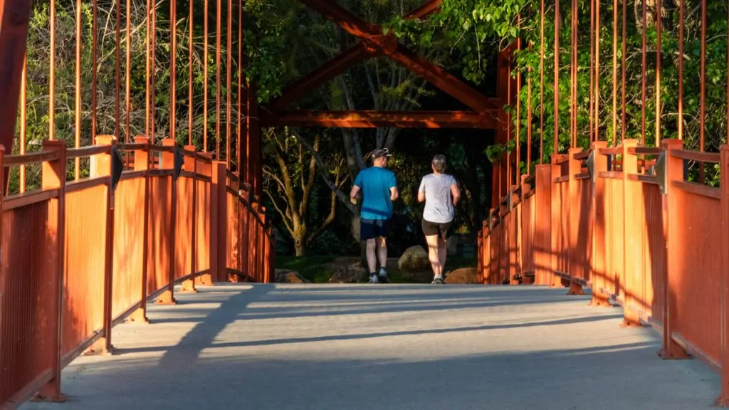 Two people jog across the Red Bridge on the Boise River Greenbelt near Warm Springs Golf Course.