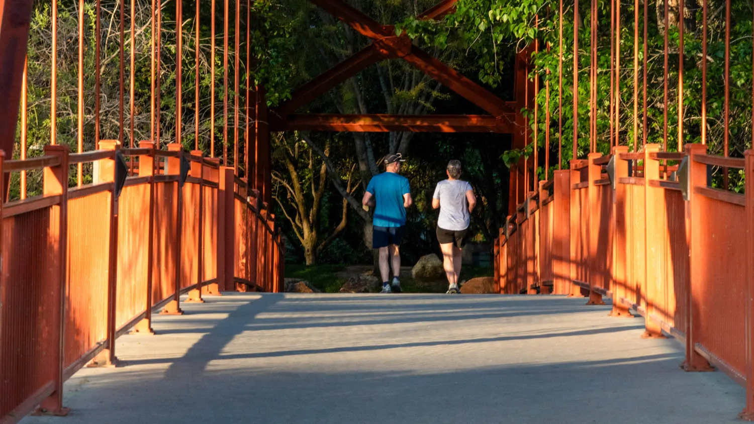 Two people jog across the Red Bridge on the Boise River Greenbelt near Warm Springs Golf Course.